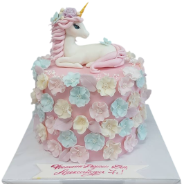 Powder pink children's cake F1771 with a sugar fondant unicorn on top and rich decoration of pastel 3D flowers,